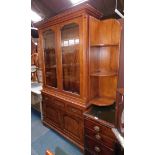 An oak bookcase, the top with a moulded and dentil cornice, above two glazed doors, enclosing shelve