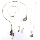 A silver lily jewellery set, comprising a bangle, torc necklace, drop necklace and a pair of earring