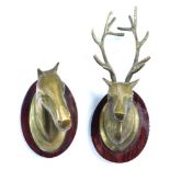A pair of brass wall plaques, modeled as a stag's head and a horse's head, raised on oval wooden pla