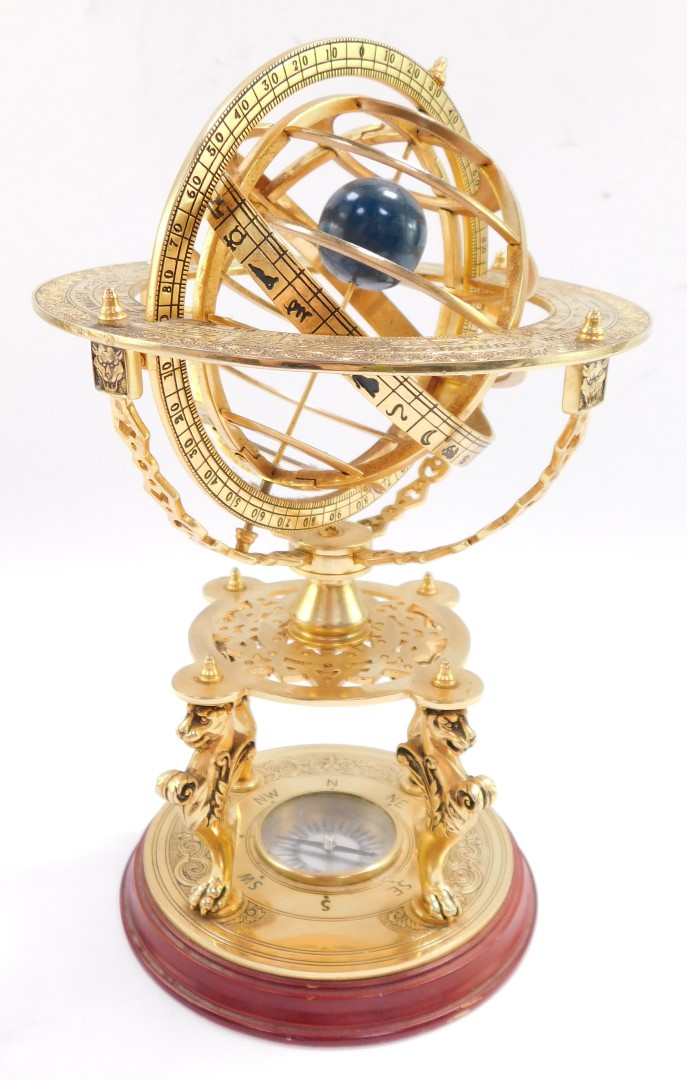 A brass orrery, with an astrological plate, raised on four supports above a table type base on three