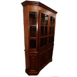 A canted oak display cabinet, with glazed astragal doors to the top, fielded paneled doors to the ba