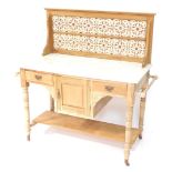 A Victorian stripped walnut washstand, the raised back with brown printed Art Nouveau style tiles, a