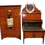 An Edwardian mahogany three piece bedroom suite, comprising wardrobe with oval bevelled mirror plate