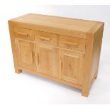 A light oak sideboard, plank top, with three frieze drawers and three paneled doors, on stiles, 87cm