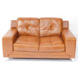 A tan leather two seater sofa, raised on metal bracket feet, 162cm long.
