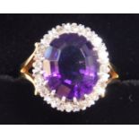 A 18ct gold and amethyst ring, oval cut in a surround of diamonds, amethyst approximately 5ct, size