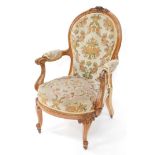 A Victorian rosewood show frame armchair, the moulded spoon shape back carved with flower heads, wit