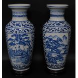 A pair of Chinese porcelain baluster vases, having blue and white landscape decoration, 54cm high wi