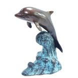 A bronze figure of a dolphin, modeled riding on the crest of a wave, 16cm high.