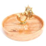 A novelty brass capstan wheel nut cracker, mounted on a walnut bowl, 26cm wide.