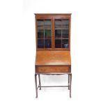 An Edwardian mahogany and satinwood cross banded bureau bookcase, the out swept pediment over a pair