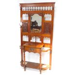 A Victorian walnut hall stand, with a central cartouche shaped mirror, with bevelled plate, surround