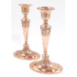 A pair of Adam style early 20thC copper candlesticks, embossed with acanthus leaves, 20cm high.