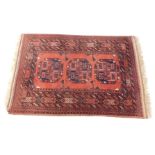 A Tekke rug, red ground decorated with three central guls, in repeating geometric borders, 153cm x 1