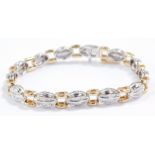 A baguette diamond bracelet, set in a white oval and yellow square metal link bracelet, stamped 14k,