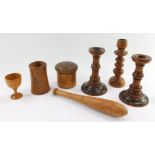 A group of treen, comprising a circular spice box and cover, three candlesticks, tapering vase, egg