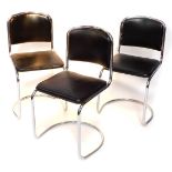 A set of three tubular chrome plated chairs, each with a black leatherette seat.