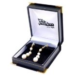 A pair of cultured pearl and diamond drop earrings, each earring set with four graduated pearls, in