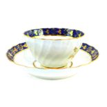 A First Period Worcester porcelain tea bowl and matching saucer, having blue scale rim with gilt fl