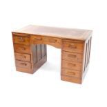 An Art Deco desk, the rectangular top with a red leather inset bordered with Greek key design in gil