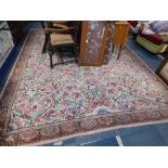 A machine made wool rug, beige ground and floral design.
