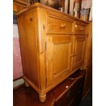 A pine side cabinet, with two drawers over two cupboard doors.