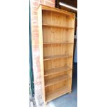 A pine bookcase enclosing five shelves.