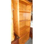 A pine bookcase, enclosing four shelves.