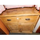 An early 20thC pine sideboard, with two drawers above cupboard doors.