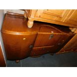 A mid 20thC walnut sideboard, enclosing a cocktail cabinet.