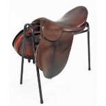 A leather riding saddle and stand.