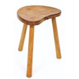 A Robert Thompson of Kilburn 'Mouseman' oak three legged stool, with shaped seat with carved mouse,