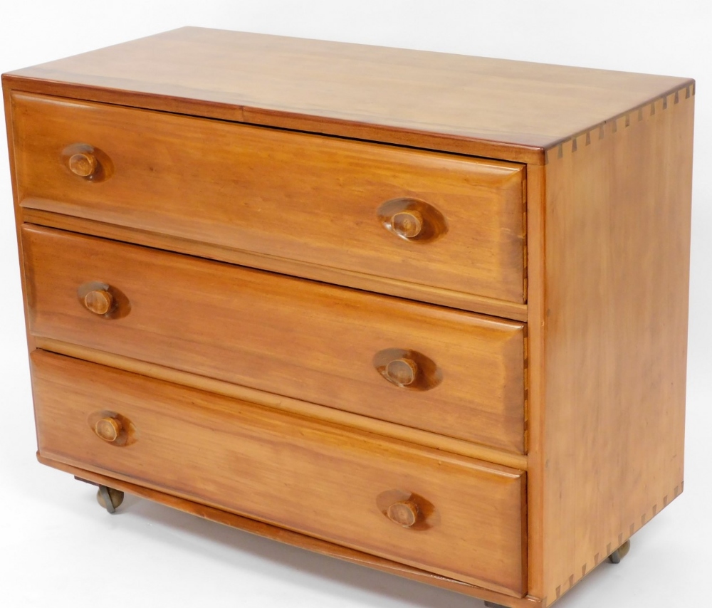 A 1970's/80's Ercol type three drawer chest, with moulded handles, 70cm high, 90cm wide, 41cm deep.