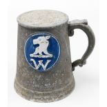 A metal ware tankard with applied blue circular crest of a dog and the letter W, 21cm high.