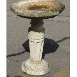 A reconstituted stone birdbath, with octagonal top on column with a rounded plinth base, 65cm high,