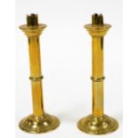 A pair of turned brass candlesticks, each with fluted top, 23cm high.