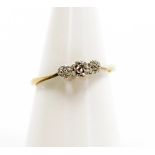 A 9ct gold and silver three stone dress ring, set with white stones in a silvered setting, ring size