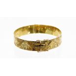 A 9ct gold hinged bangle, with etched floral design, and safety clasp, 6.5cm wide, 21.8g.