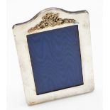 An Elizabeth II silver photograph frame, of rectangular design with arched top and applied floral ba