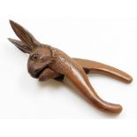 A Black Forest late 19thC pair of nut crackers, carved as the head of a hare, inset glass eyes, 23cm