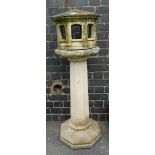 A reconstituted stone bird table, with folly shaped top and large column on octagonal base, 124cm hi