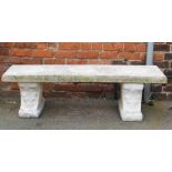 A reconstituted stone garden bench, the rectangular top on two plinths, 41cm high, 140cm wide, 37cm