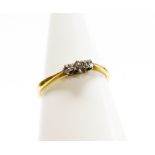 An 18ct gold three stone diamond dress ring, set with three tiny diamonds, in a platinum setting, ri