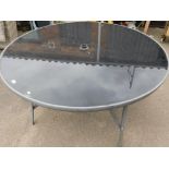 A large circular glass top garden table.