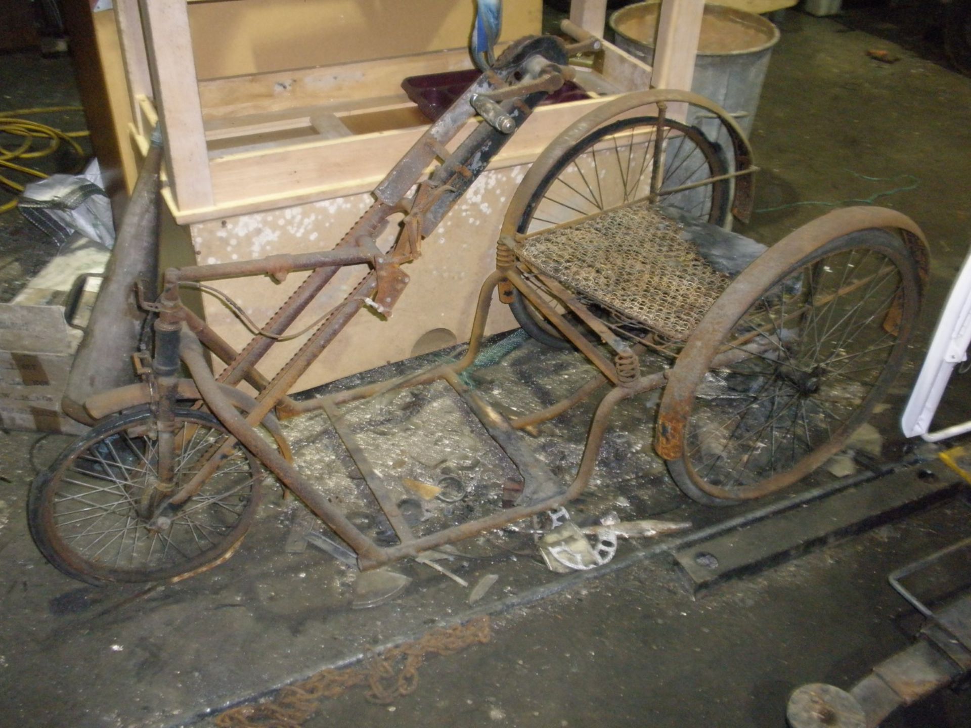 A vintage hand driven low tricycle carriage.