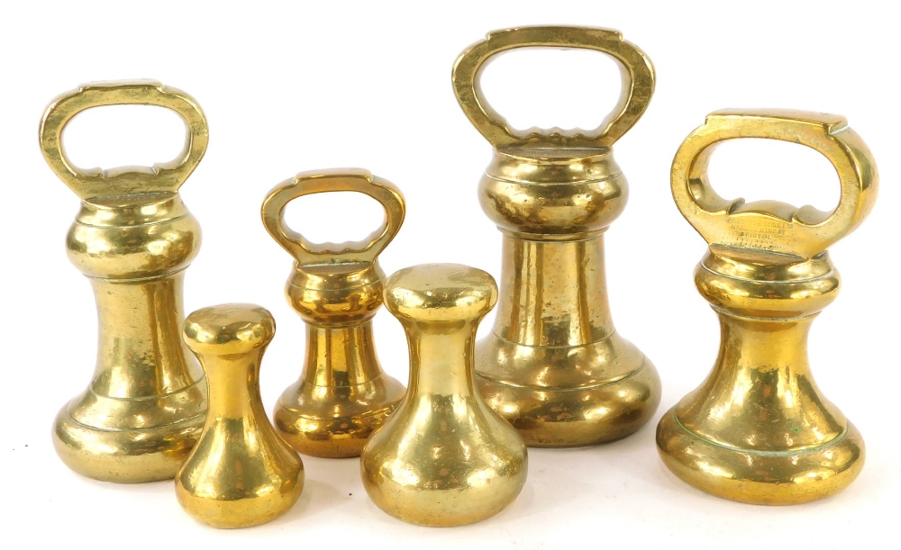 A graduated set of six brass bell weights, to include 7lb, two 4lb, 2lb, 2ln dumb weight and a 1lb d