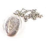 A silver oval locket pendant and chain, the locket with engraved floral design, 4.5cm high, on a sil