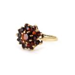 A 9ct gold floral cluster ring, set with three tiers of round brilliant cut garnets, in claw setting