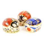 Three Royal Crown Derby porcelain paperweights, a Millennium bug, with gold coloured stopper, and tw