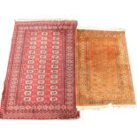 Two Afghan Belouch rugs, each with a design of medallions on a red ground.